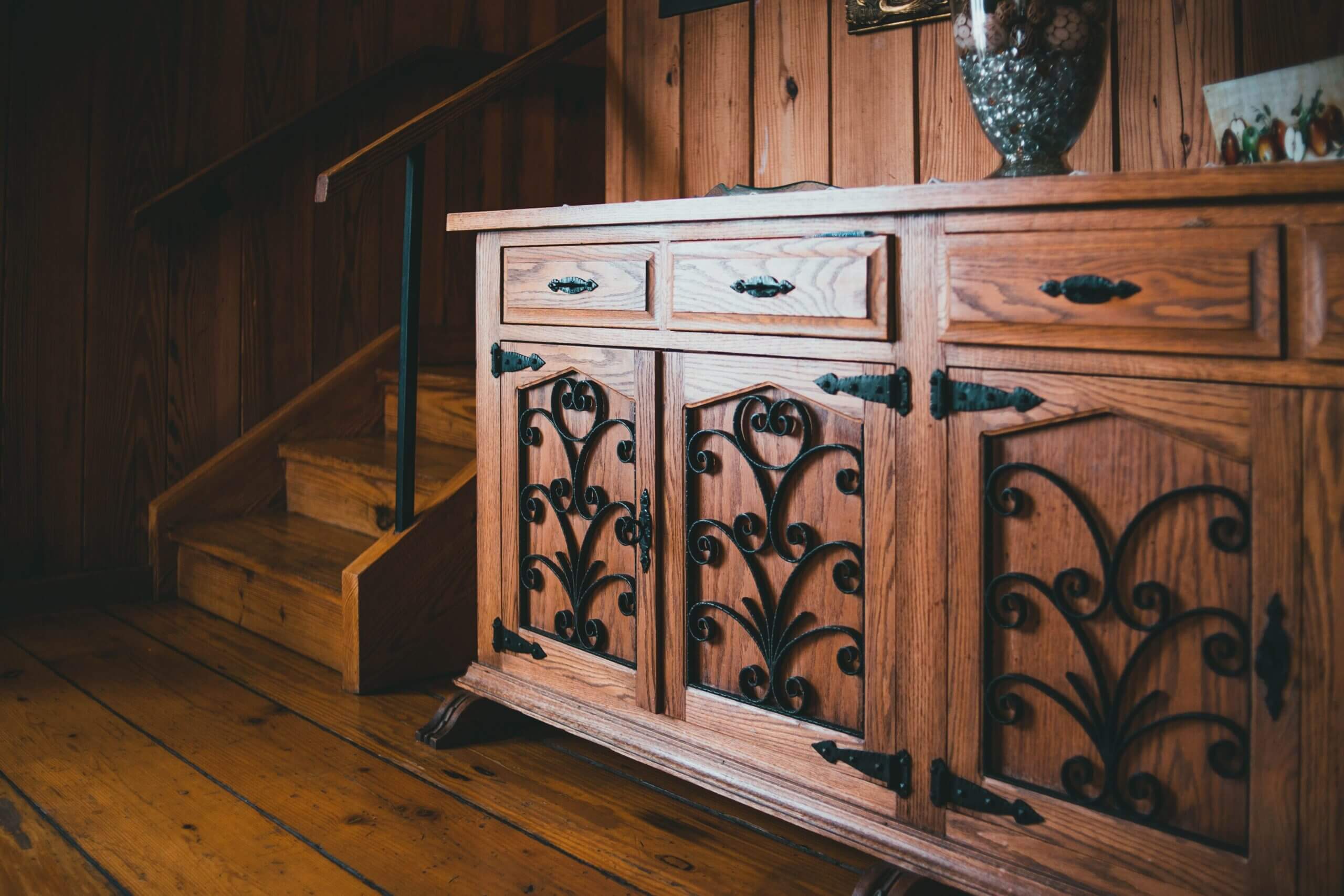 Warm wooden sideboard and staircase in a cozy, rustic interior.